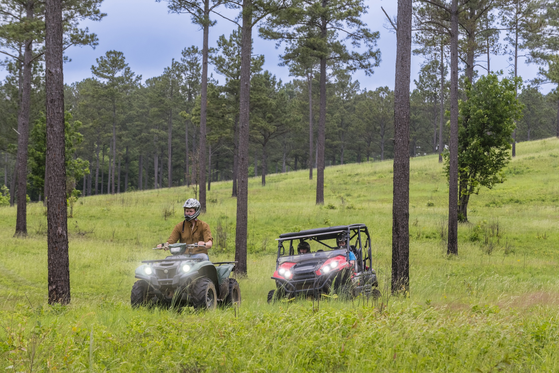 Two UTVs driving through a field at Barnsley Resort.