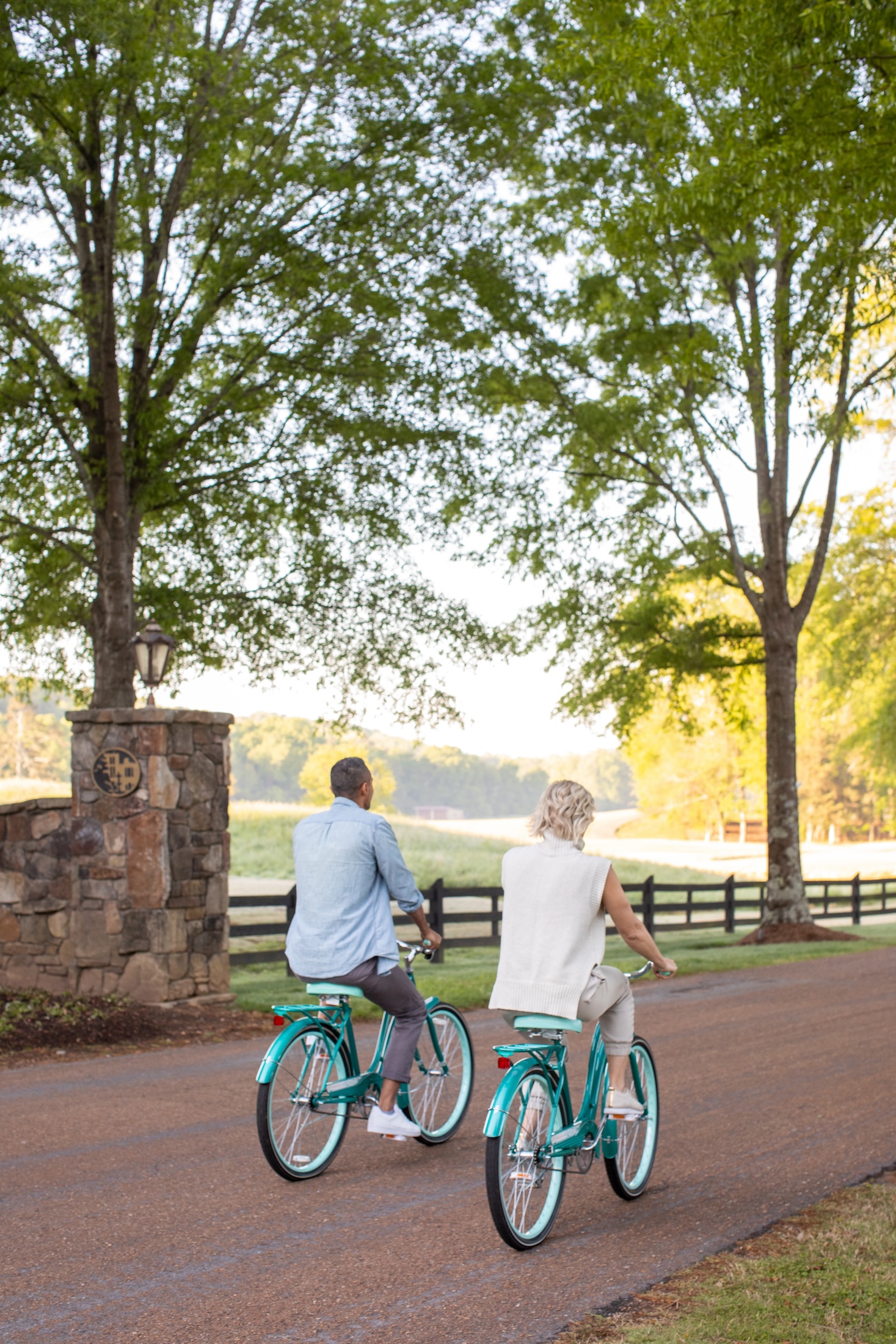 A couple biking on a tree-lined, maintained trail at Barnsley Resort.