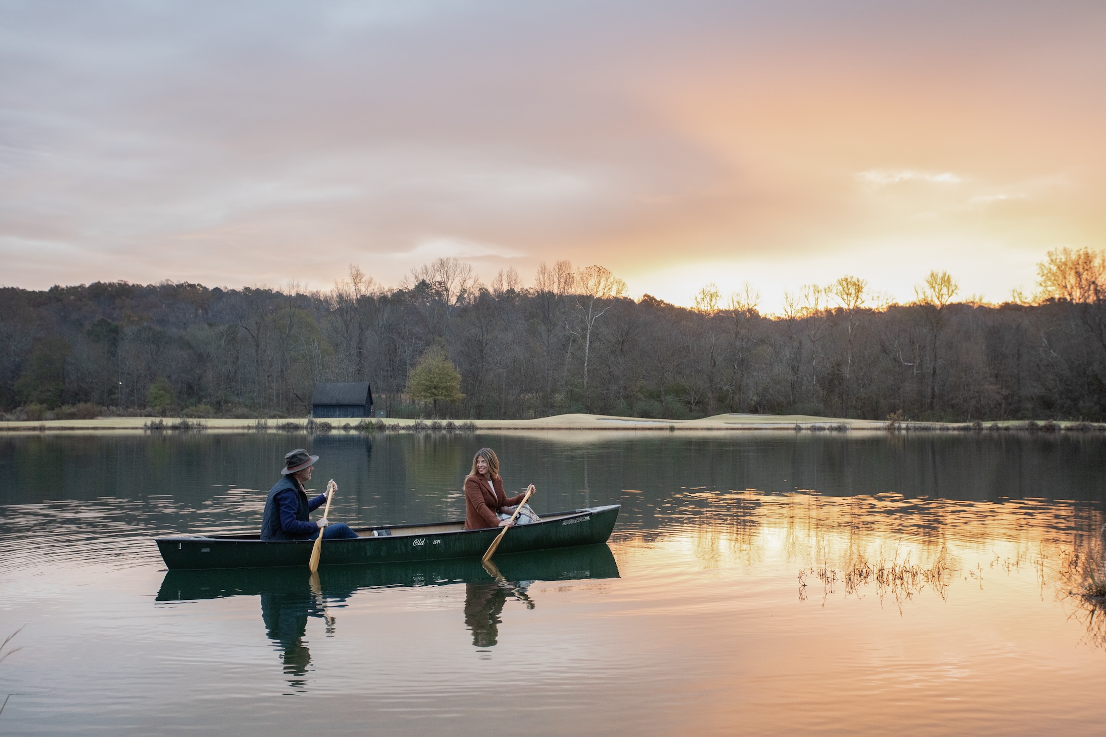 A couple canoeing at sunset on a fall day at Barnsley Resort.