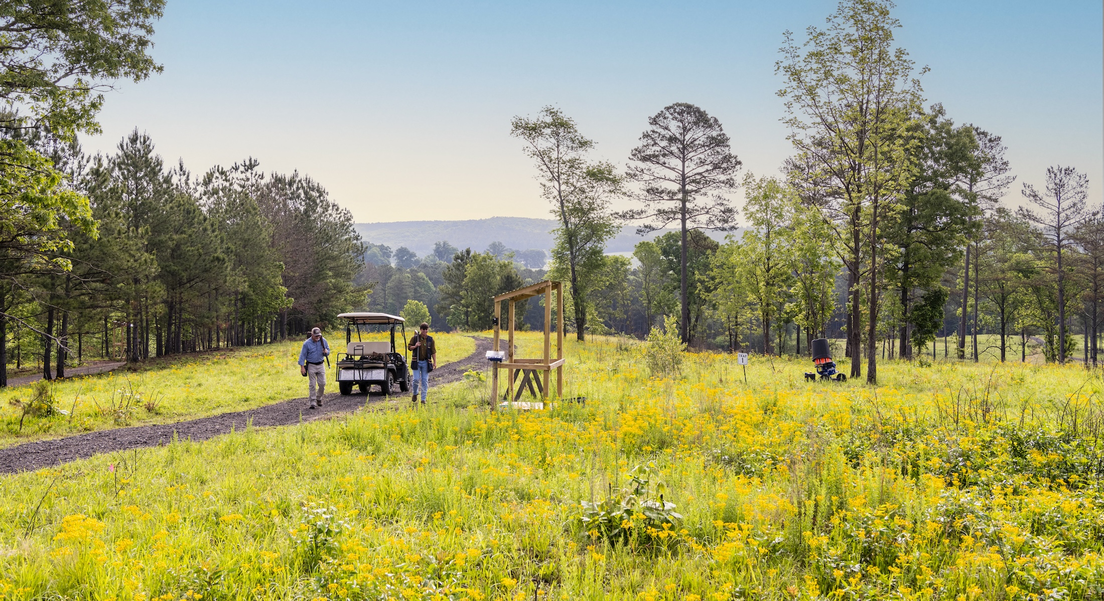 Two men walk from a golf cart to a shooting station at Barnsley Resort.