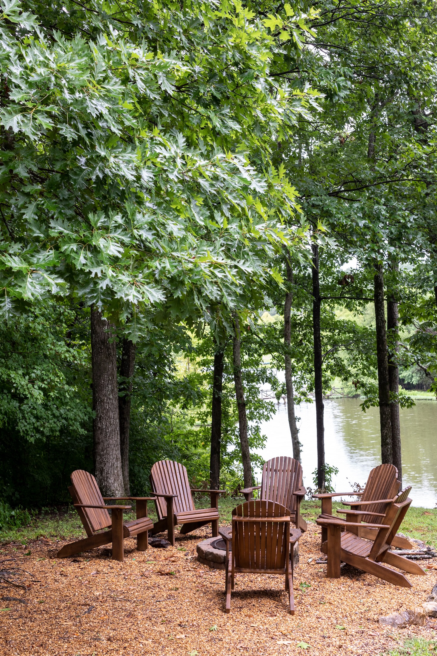 A fire pit area next to a lake at the Fugger Cabin at Barnsley Resort.