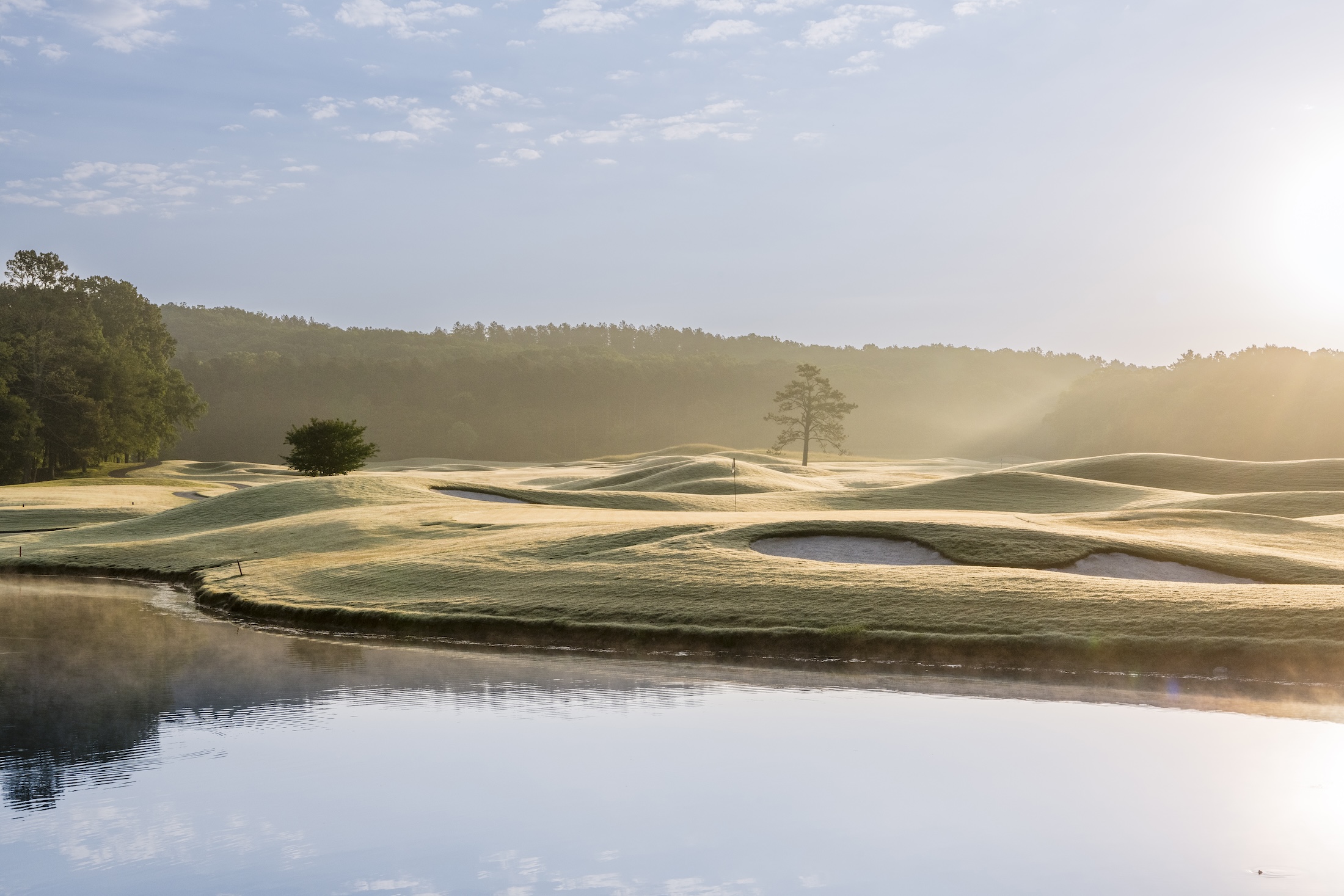 A serene golf course at sunrise.