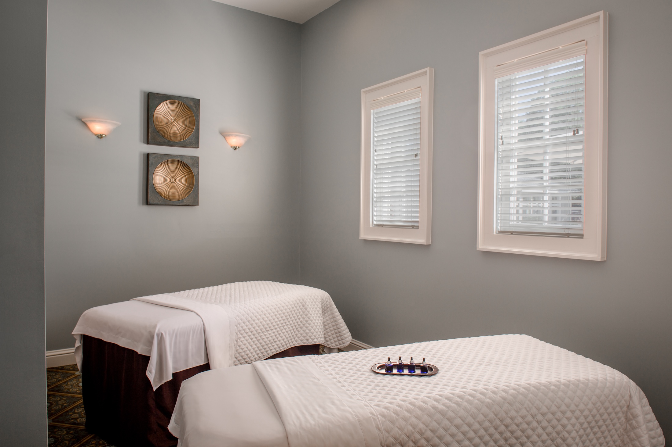 A couples massage room set up with two beds and massage oils at Barnsley Resort.