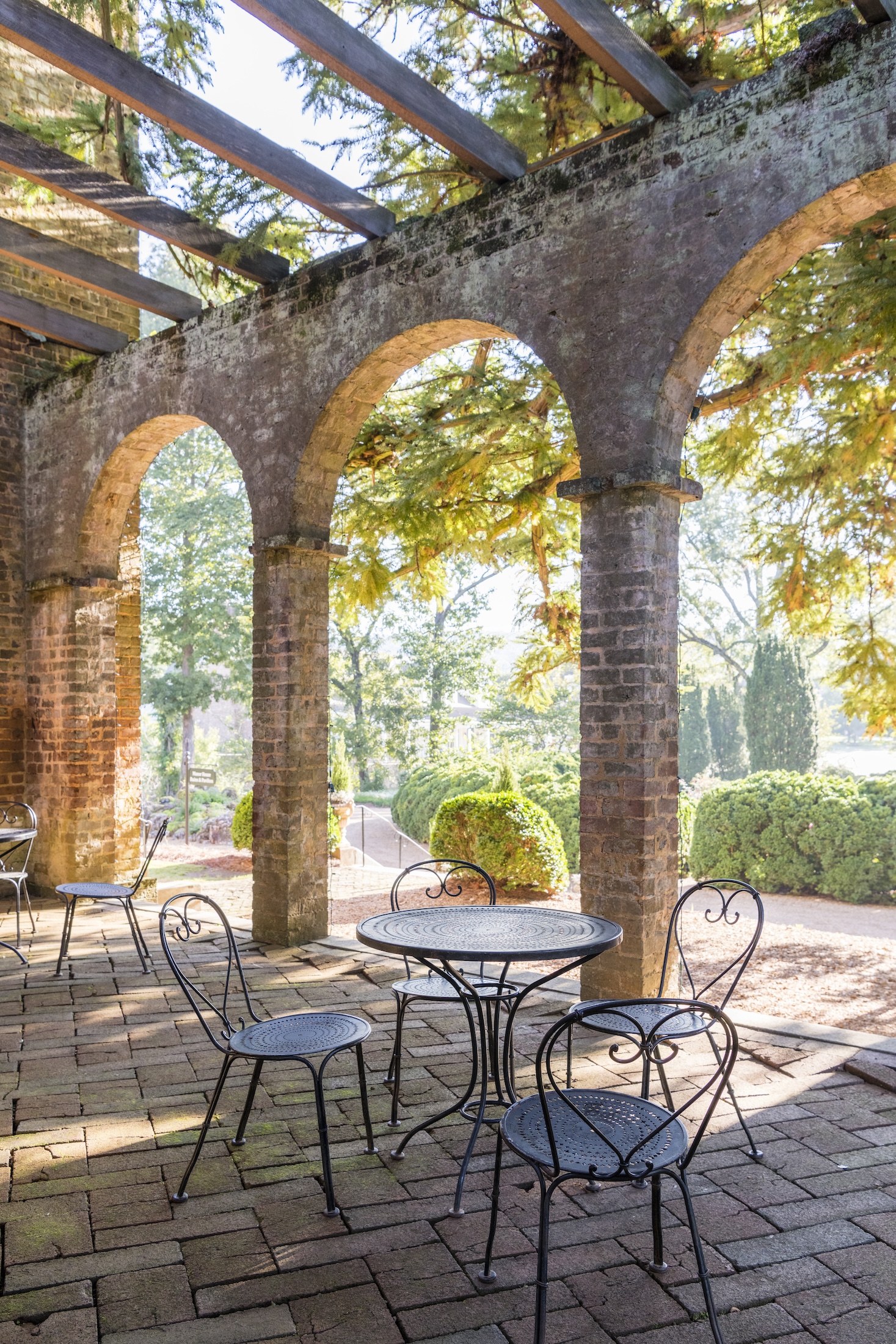 A table and charis is set up within the Manor House Ruins on a sunny day at Barnsley Resort.