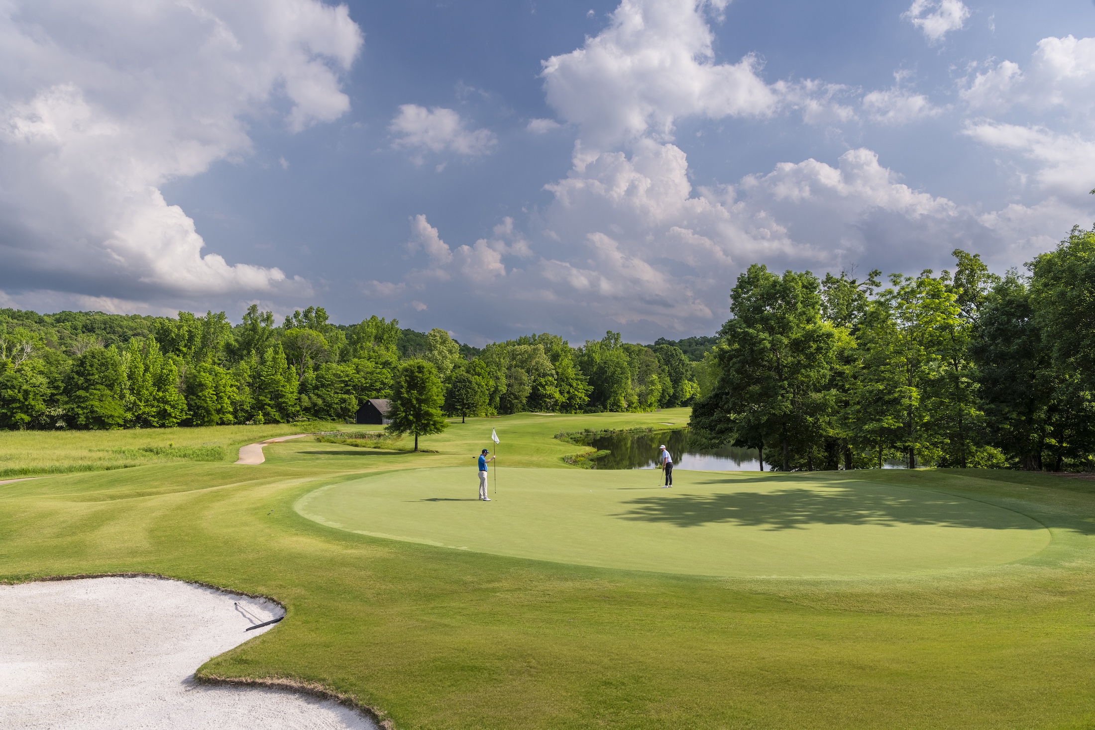 Two people playing golf on a sunny day.