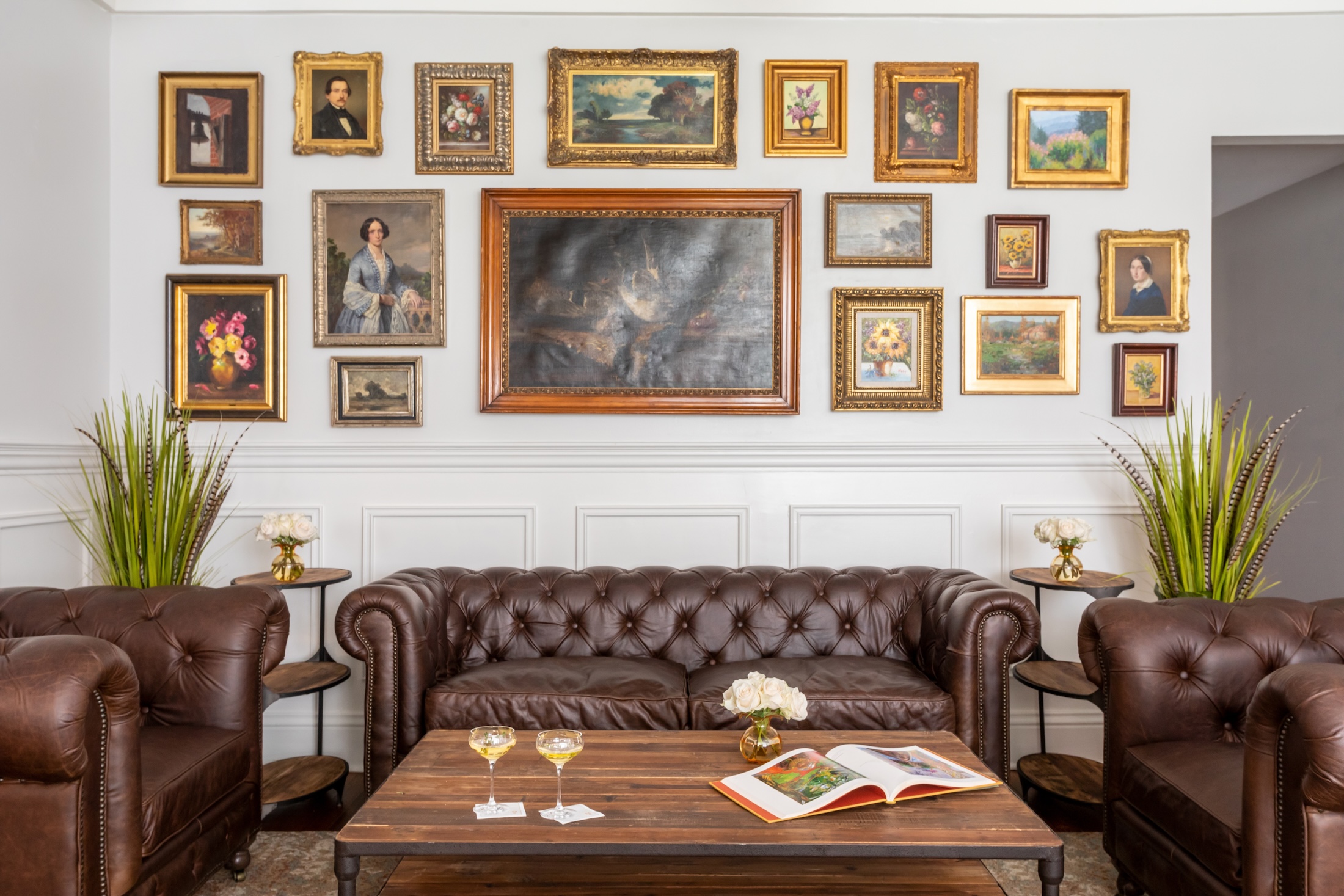 The Rice House Lounge with comfortable leather sofas and an ornate gallery wall.