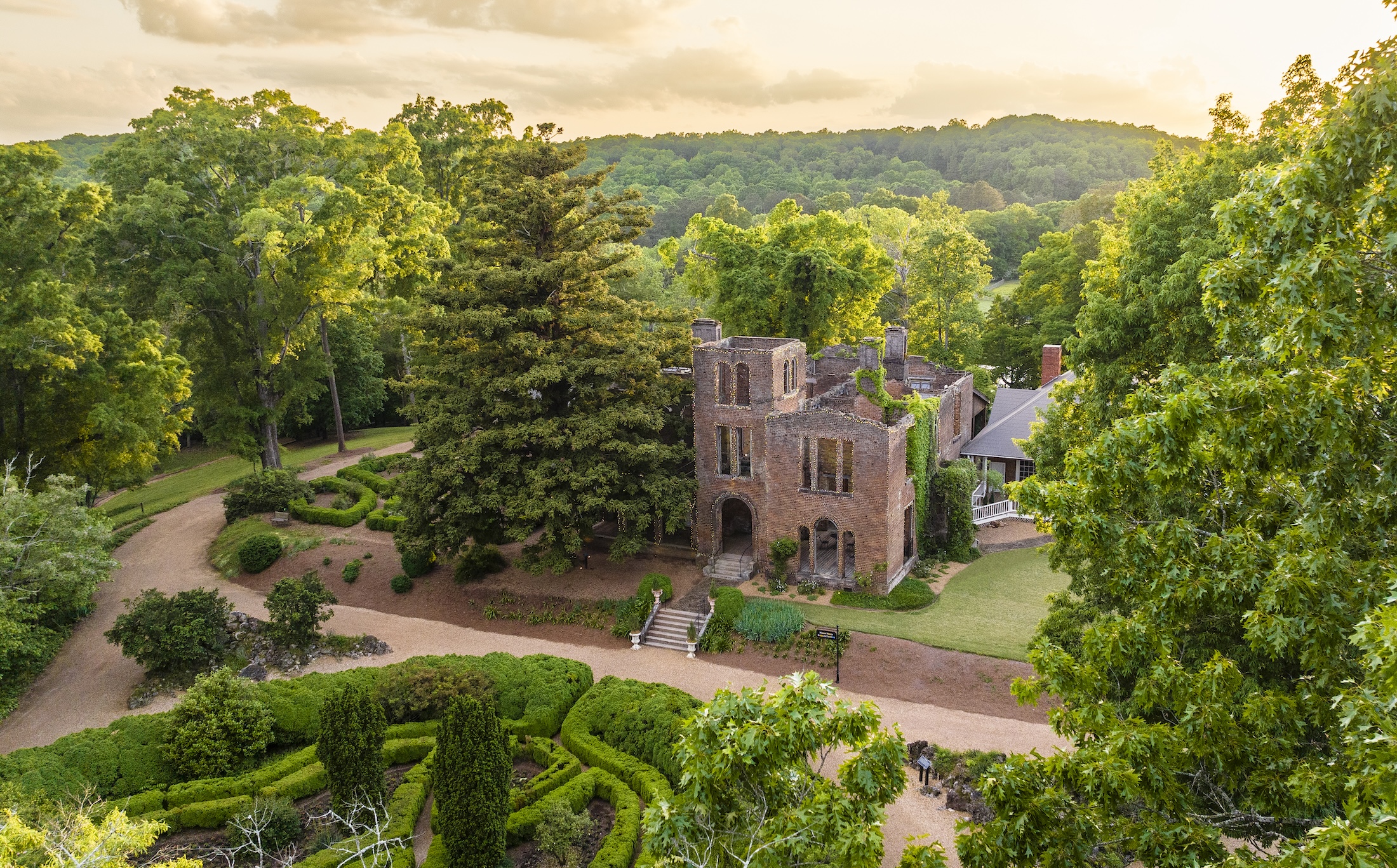 An aerial view of Manor House Ruins and gardens at sunrise.