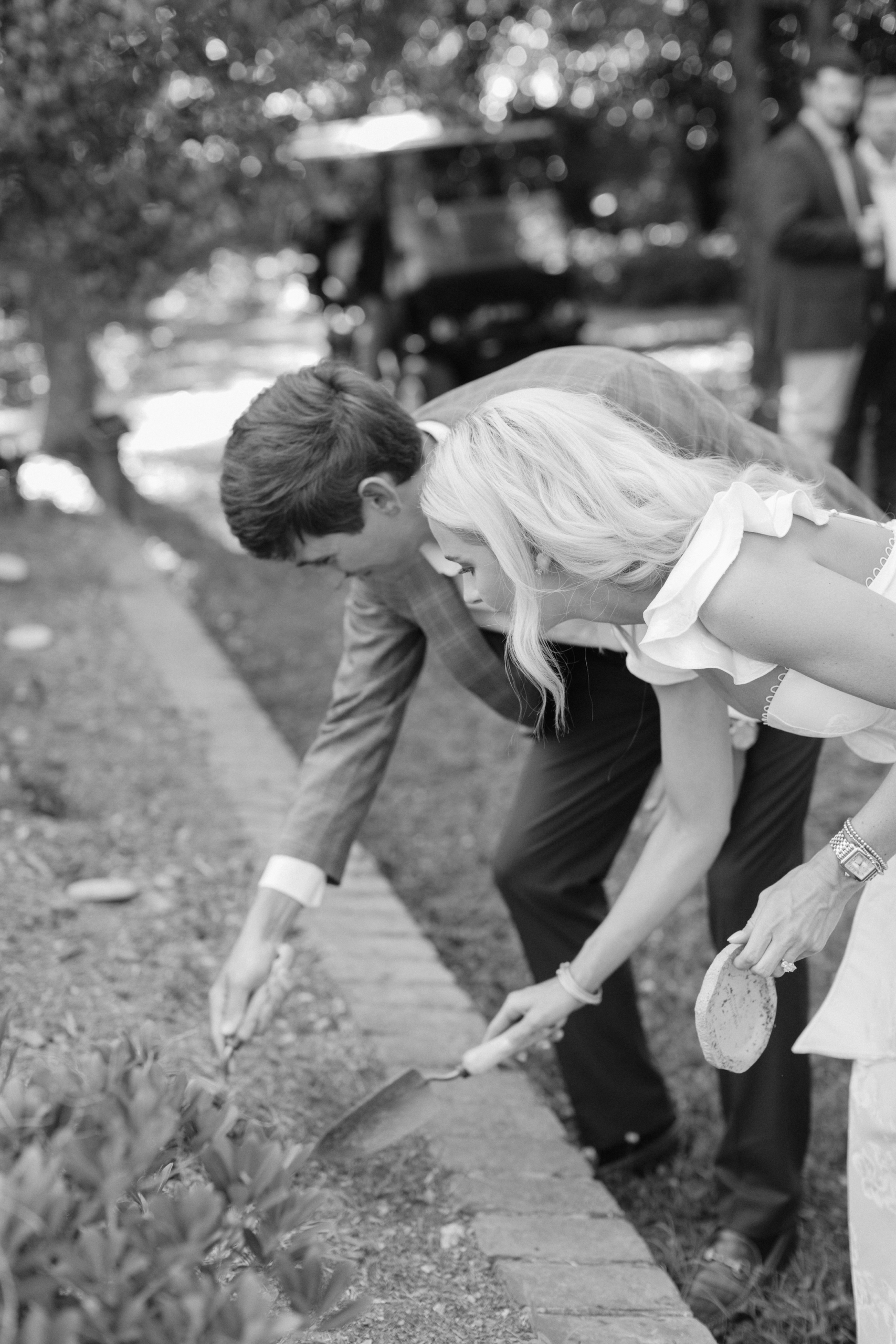 A bride and groom dig a hole during the Bourbon Ritual at a wedding at Barnsley Resort. Image credit to Amelia Skye Cinema.