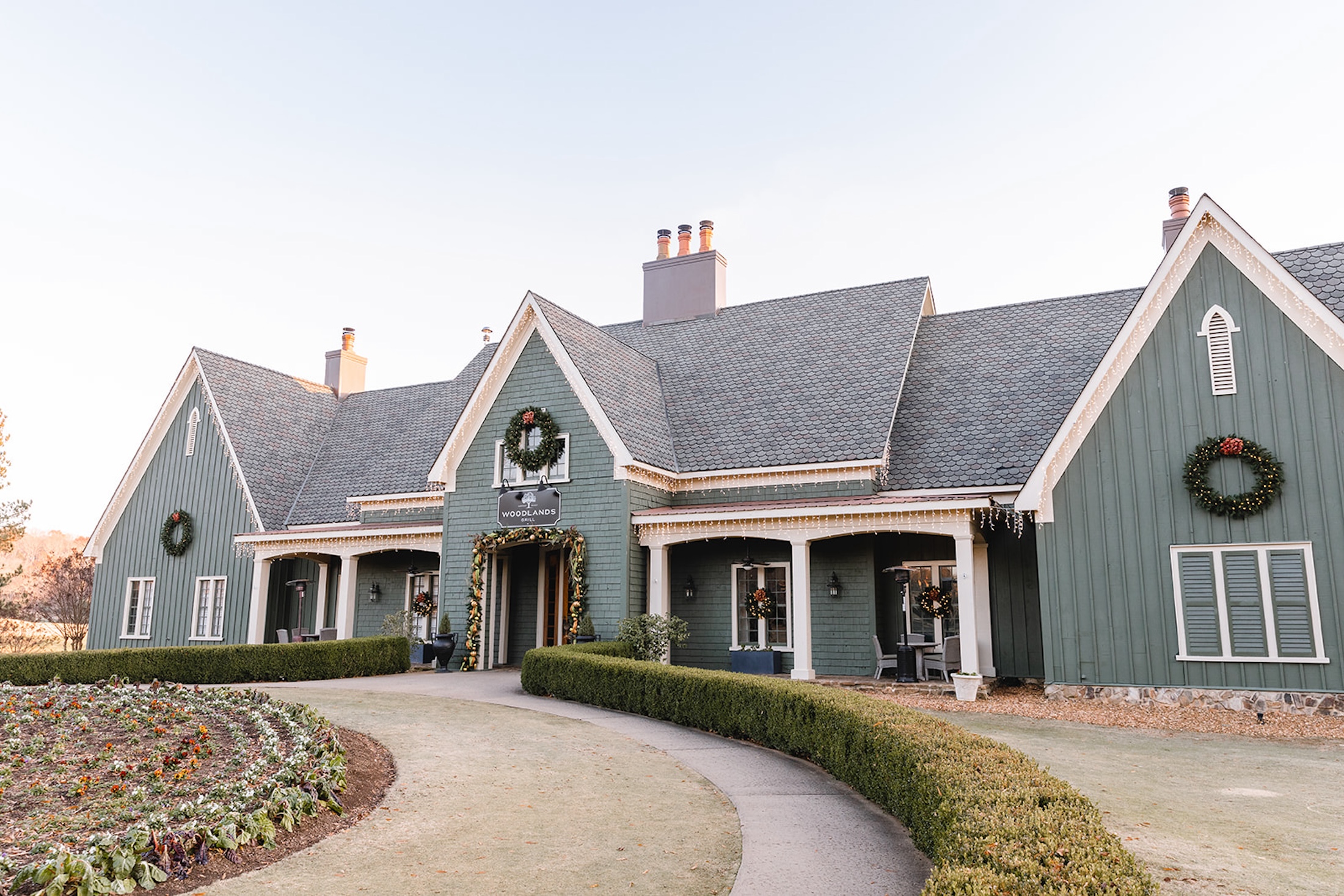 The exterior of Woodlands Grill decorated with wreaths, lights and garland.