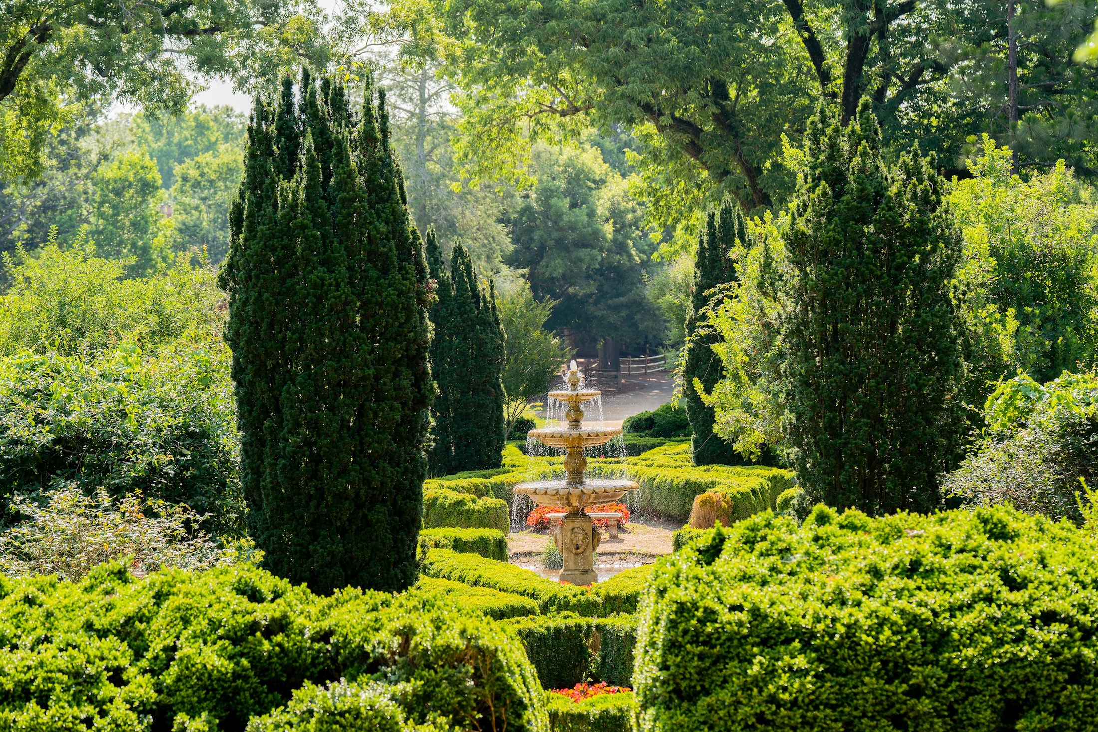 A water fountain in a lush garden on a sunny day.