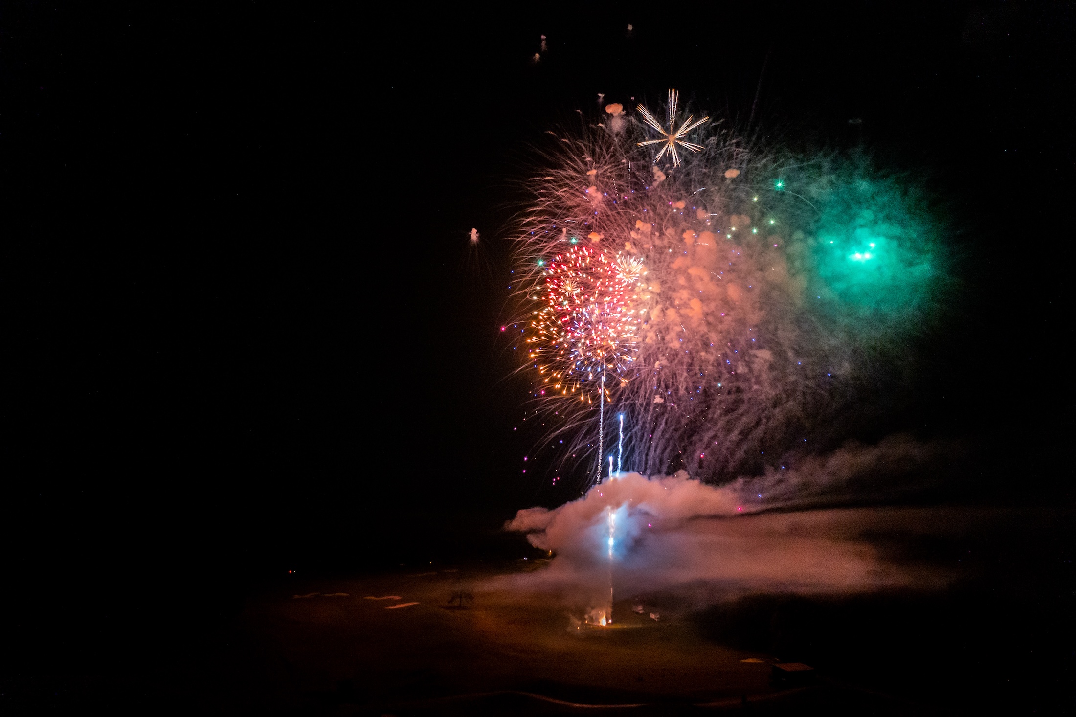 Fireworks light up a night sky in red and blue.