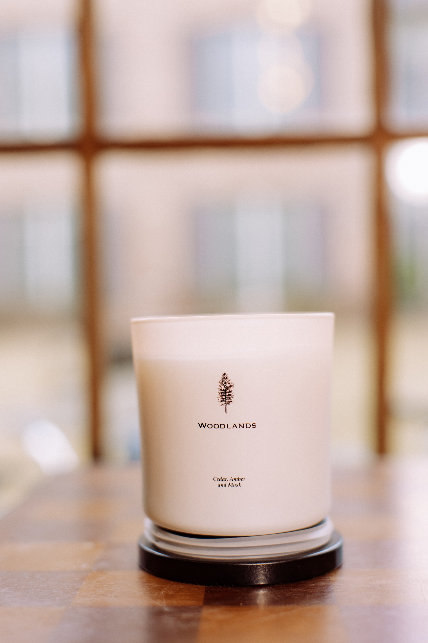 A candle branded with Woodlands.