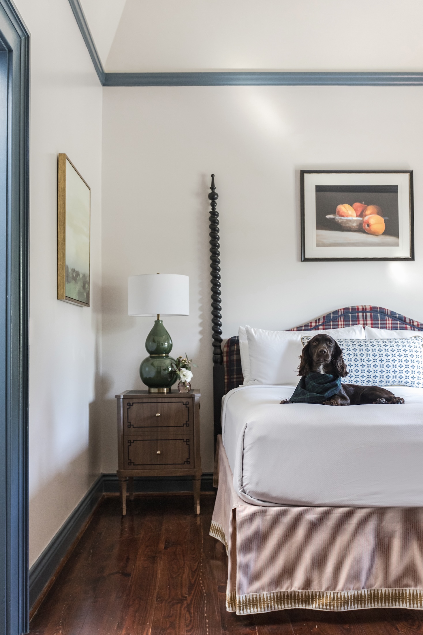 A dog lays on a bed in a cottage bedroom at Barnsley Resort.