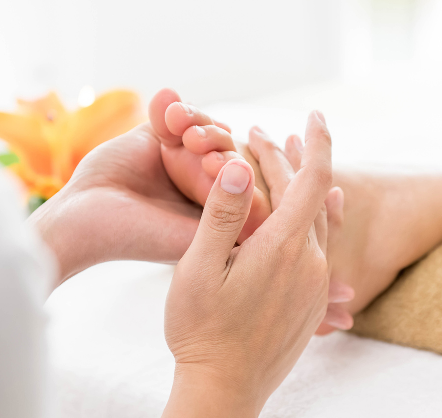 A spa worker giving reflexology treatment to a guest's foot.