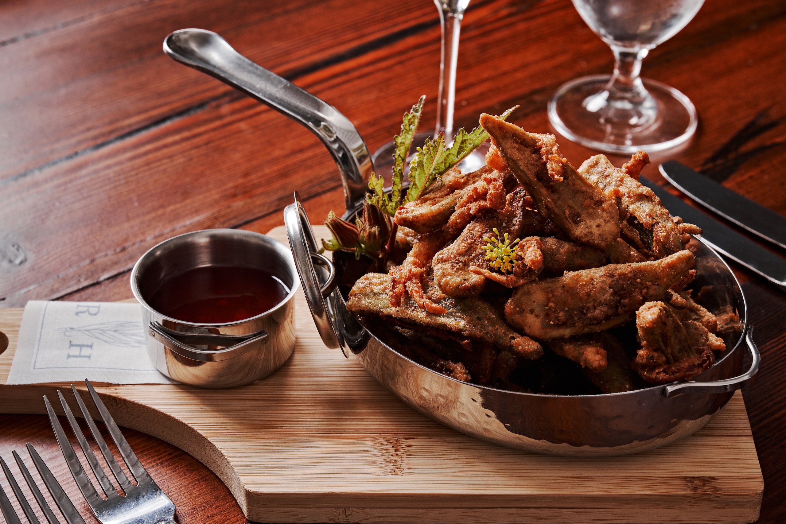 A pot of fried chicken wings with sauce on the side at Rice House restaurant.