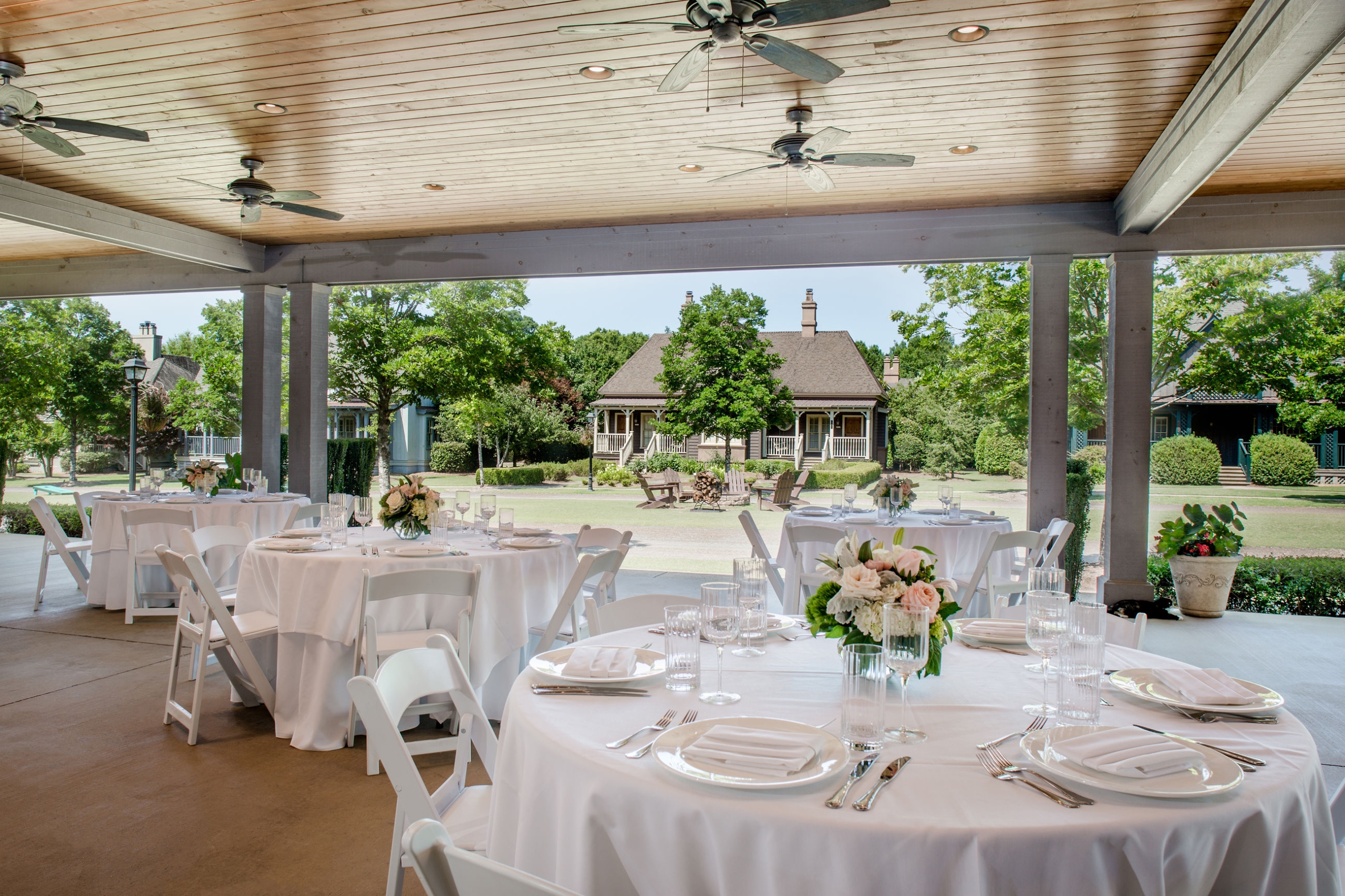 Multiple round tables set for a wedding reception on Saylor Hall Terrace. The village at Barnsley Resort can be seen in the background.