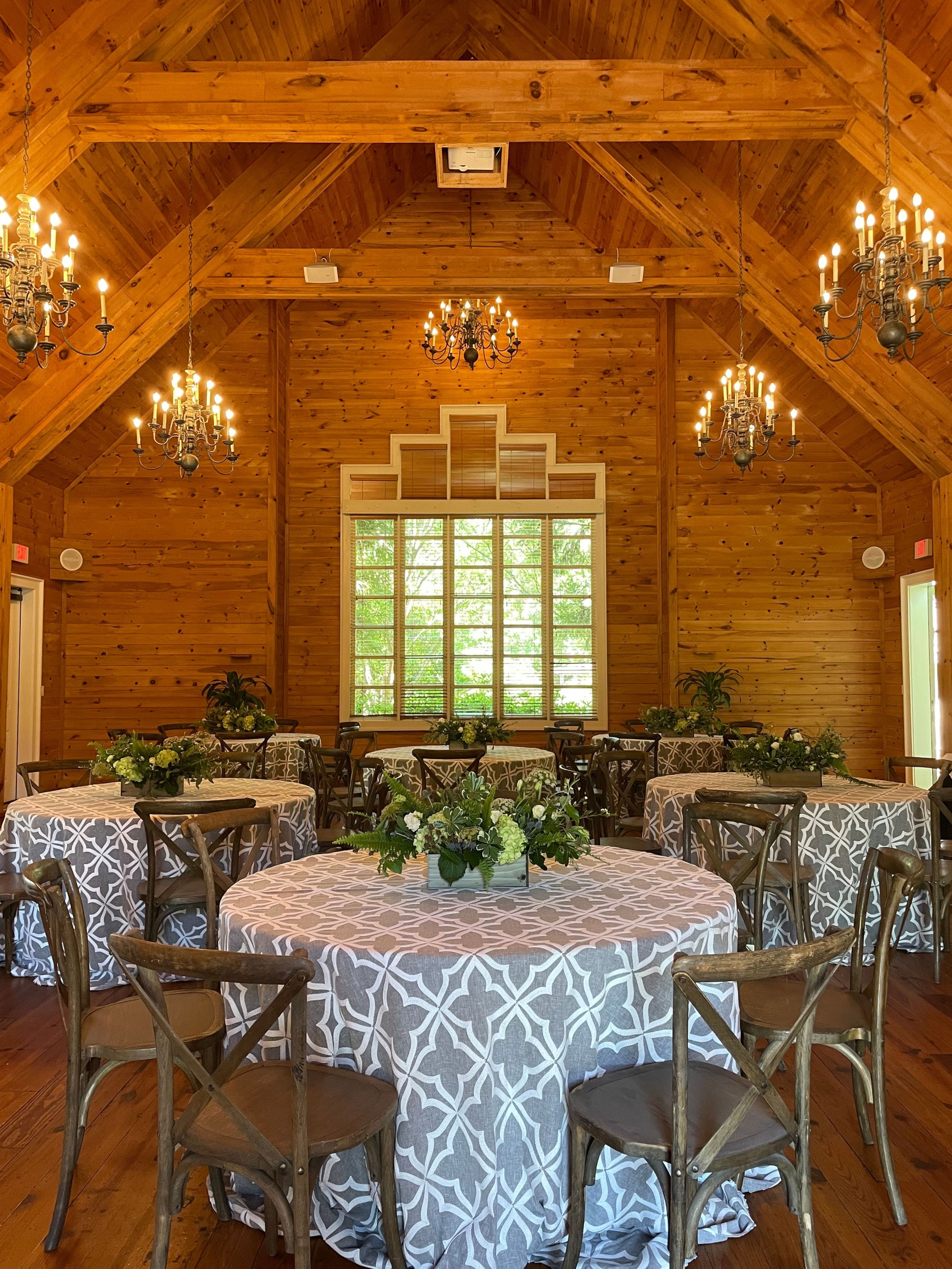 The interior of Town Hall with multiple small circular tables set up with table cloths and floral arrangements.